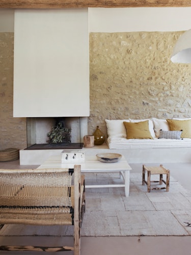 A living room with beige furniture and an avantgarde white fireplace