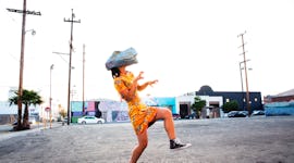 Young woman wearing a dinosaur mask making an epic Boomerang to post on Instagram with a fun caption...