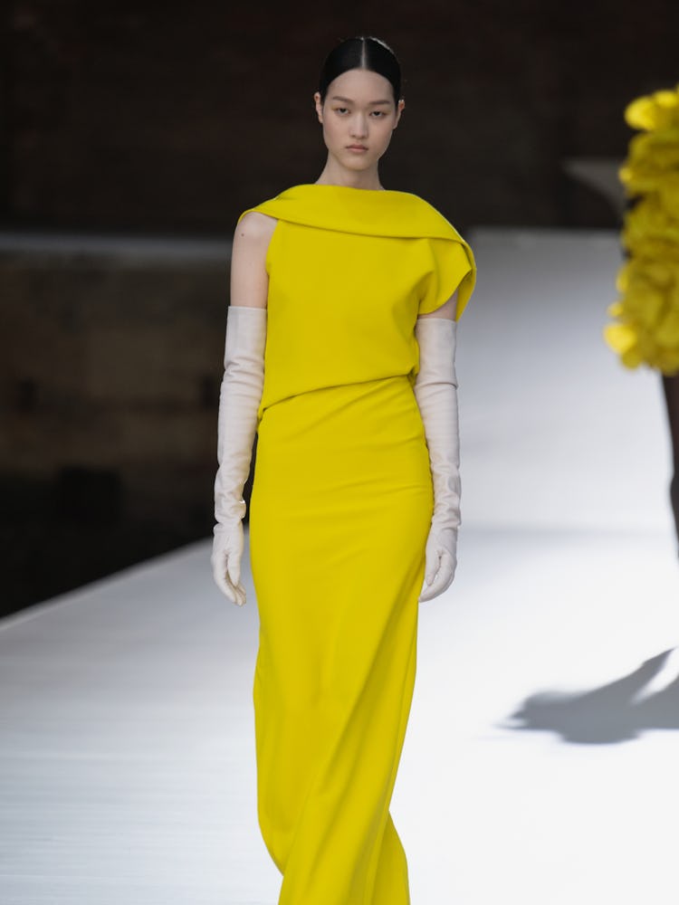A model in a yellow dress and white gloves at the Valentino Couture Fall 2021 Couture