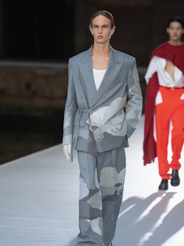 A model in a grey suit with illustrations at the Valentino Couture Fall 2021 Couture