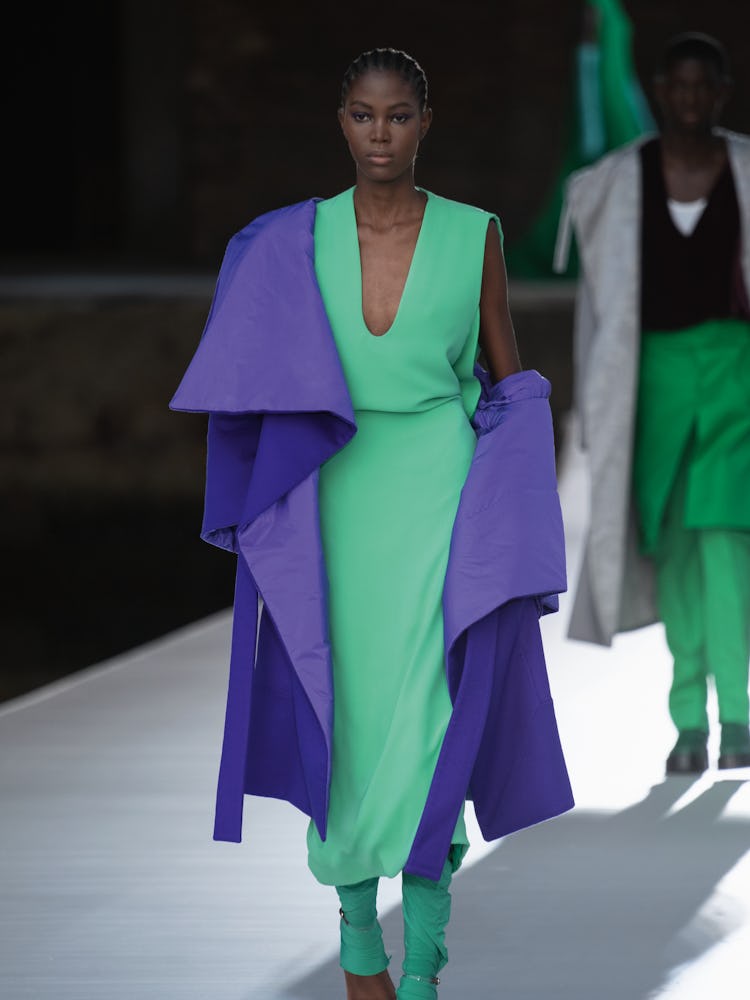 A model in a green dress and purple coat at the Valentino Couture Fall 2021 Couture