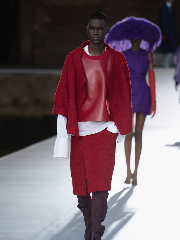 A model in a red top, jacket and skirt at the Valentino Couture Fall 2021 Couture