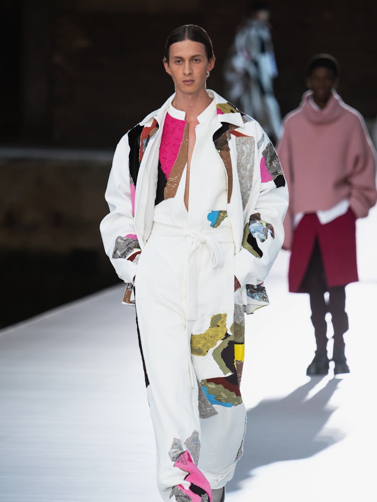 A model in a white illustrated suit at the Valentino Couture Fall 2021 Couture