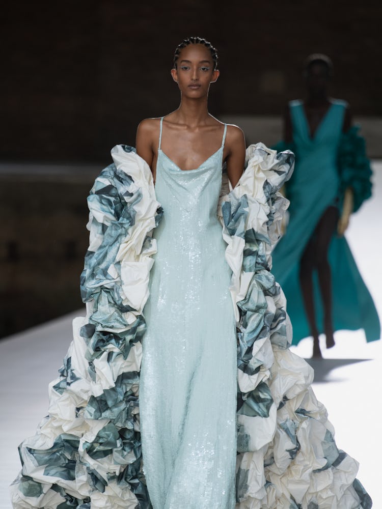 A model in a mint shimmer dress and white-mint cape at the Valentino Couture Fall 2021 Couture