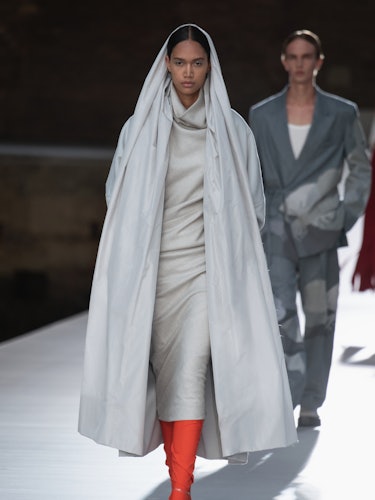 A model in a grey dress and hooded coat at the Valentino Couture Fall 2021 Couture
