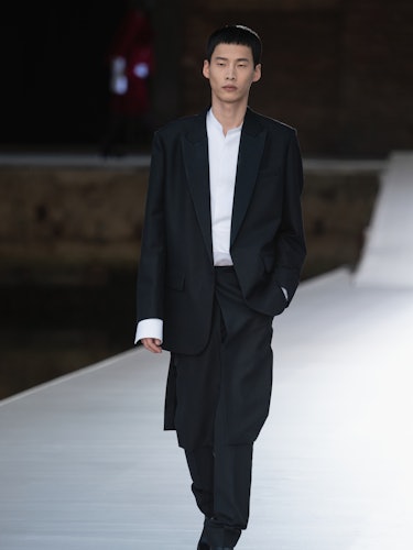 A model in a black suit and a white shirt at the Valentino Couture Fall 2021 Couture