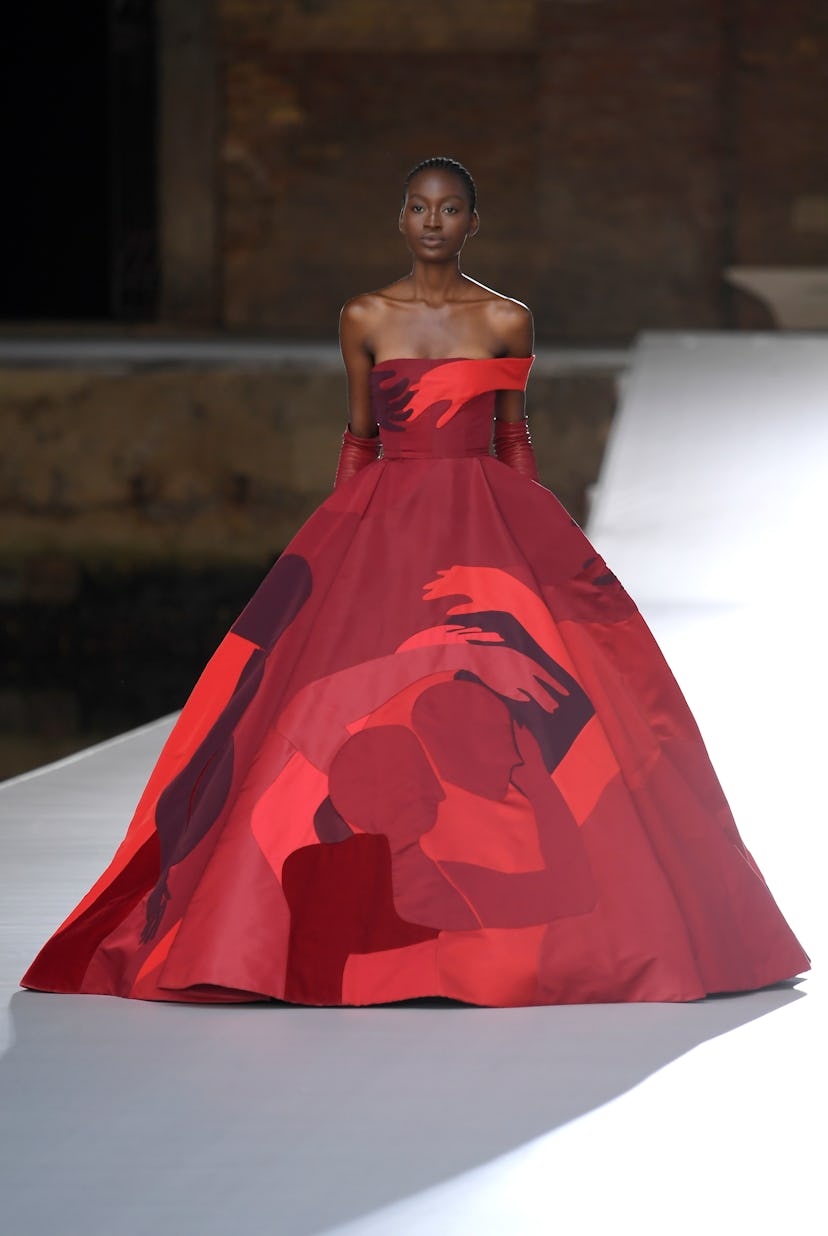 A model in a red gown with illustrations at the Valentino Couture Fall 2021 Couture