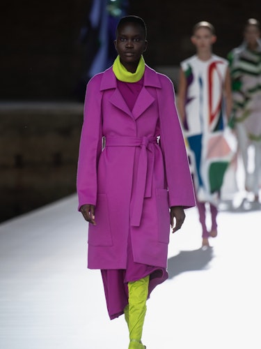A model in a purple coat and lime boots at the Valentino Couture Fall 2021 Couture