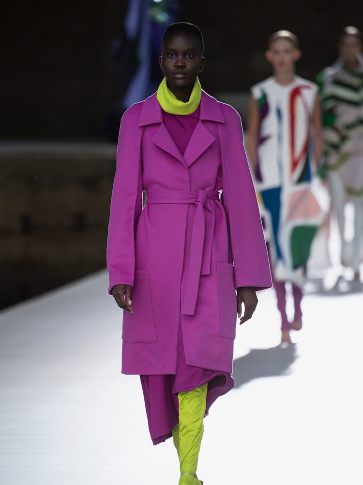 A model in a purple coat and lime boots at the Valentino Couture Fall 2021 Couture