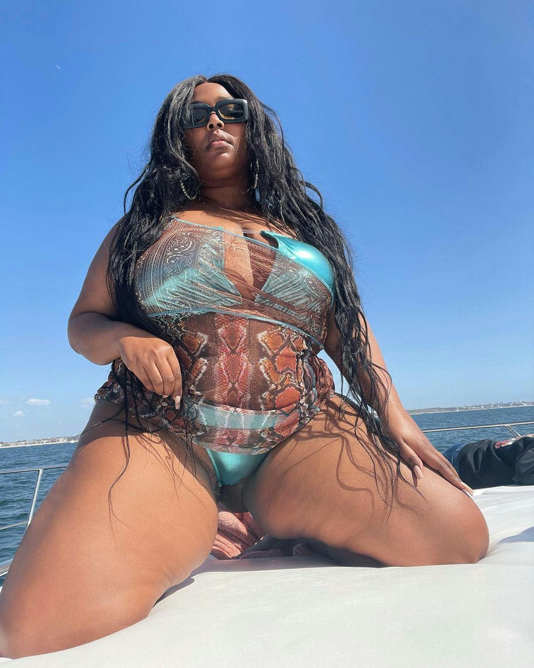 Lizzo wears shimmery blue swimsuit and animal print coverup in her Instagram photo from March 2021.
