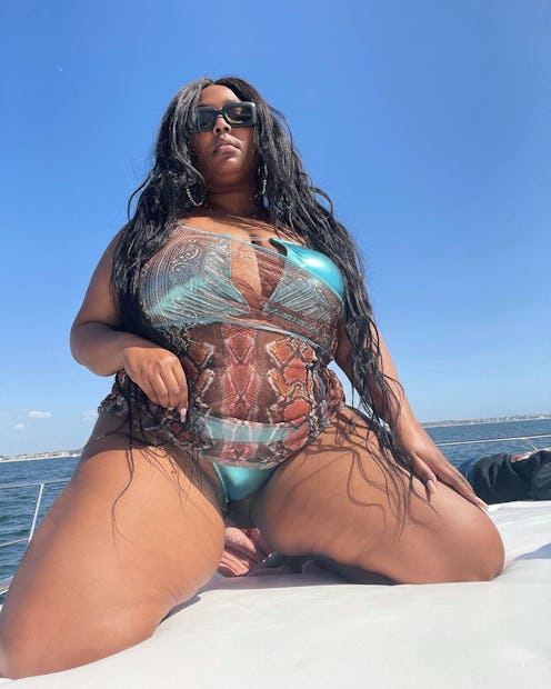 Lizzo wears shimmery blue swimsuit and animal print coverup in her Instagram photo from March 2021.
