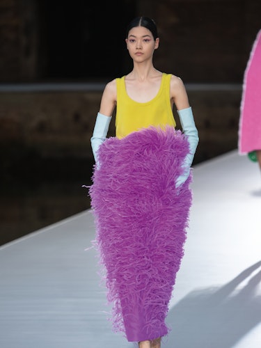 A model in a yellow top and a purple feather skirt at the Valentino Couture Fall 2021 Couture