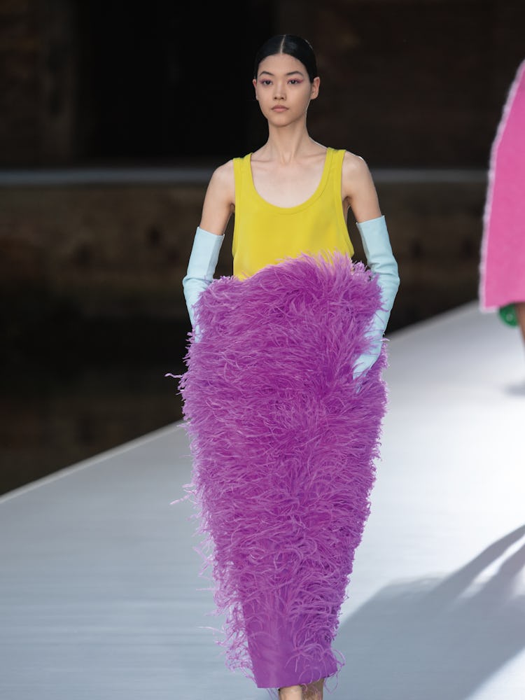 A model in a yellow top and a purple feather skirt at the Valentino Couture Fall 2021 Couture