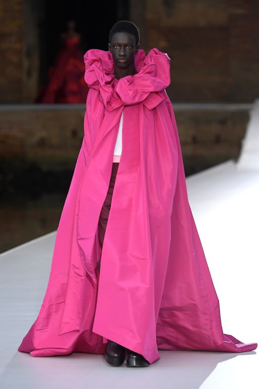 A model in a long pink cape with frill detail at the Valentino Couture Fall 2021 Couture