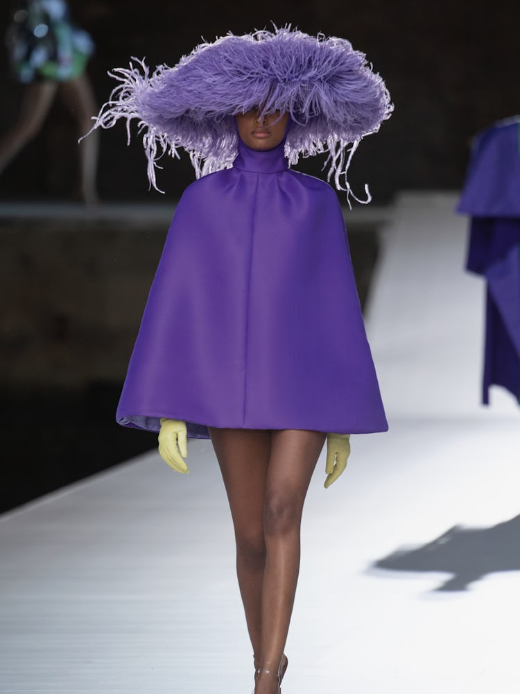 A model in a short purple cape-dress at the Valentino Couture Fall 2021 Couture