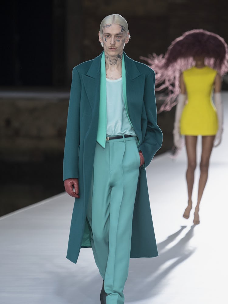 A model in a mint shirt and pants and teal coat at the Valentino Couture Fall 2021 Couture