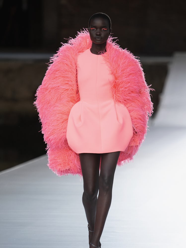 A model in a salmon dress and feathered jacket at the Valentino Couture Fall 2021 Couture