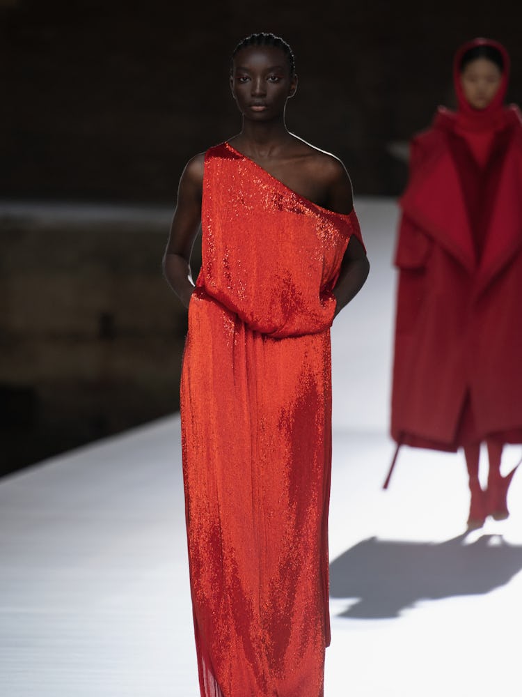 A model in a red shimmer jumpsuit at the Valentino Couture Fall 2021 Couture
