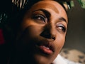 Young woman looking out a window to show the emotional meaning of the July 2021 full moon in Aquariu...