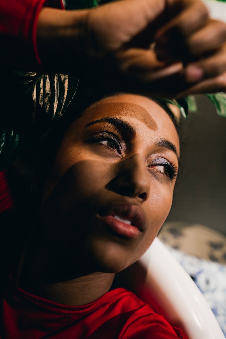 Young woman looking out a window to show the emotional meaning of the July 2021 full moon in Aquariu...