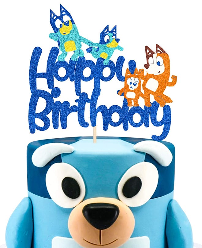 "Bluey" birthday cake with a cake topper that says "happy birthday" with "Bluey" characters on it