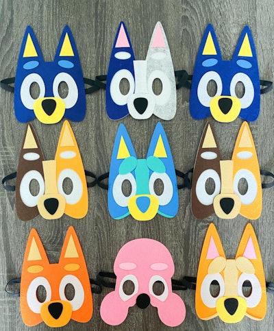 Nine "Bluey" character masks laying on a table