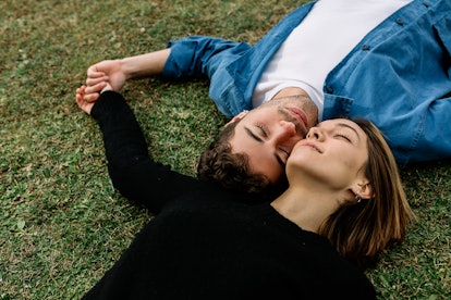 Young couple laying in grass together, celebrating their one-year anniversary with Instagram caption...