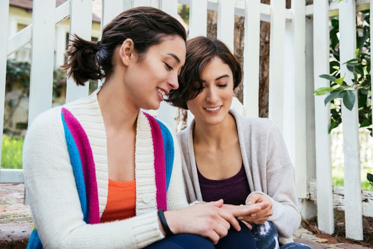 Young woman wishing her sister a happy engagement as she shows off her ring before posting on Instag...