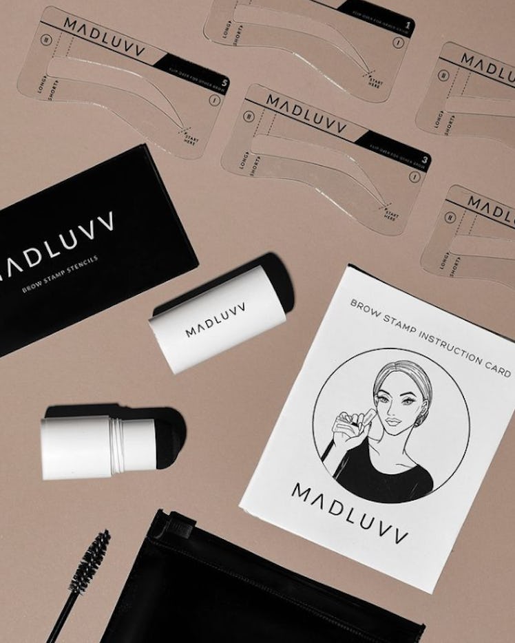 A photo of the contents of Maduvv's Brow Stamp Kit including stencils, brow pomade, and a spoolie.