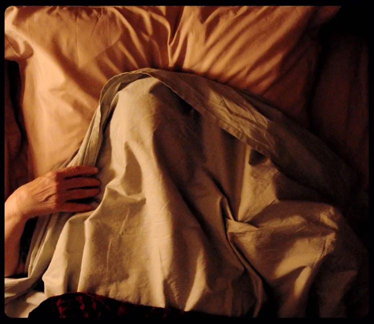 A character under a blanket in bed in Vortex movie