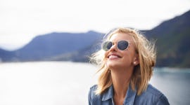 Young woman relaxing out on the water with the wind in her hair, in need of lake Instagram captions.