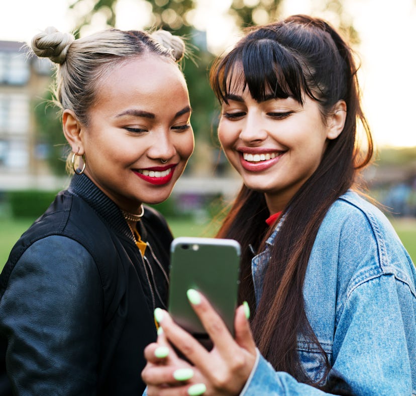 Smiling friends talking selfie before heading back to school and posting on Instagram with throwback...