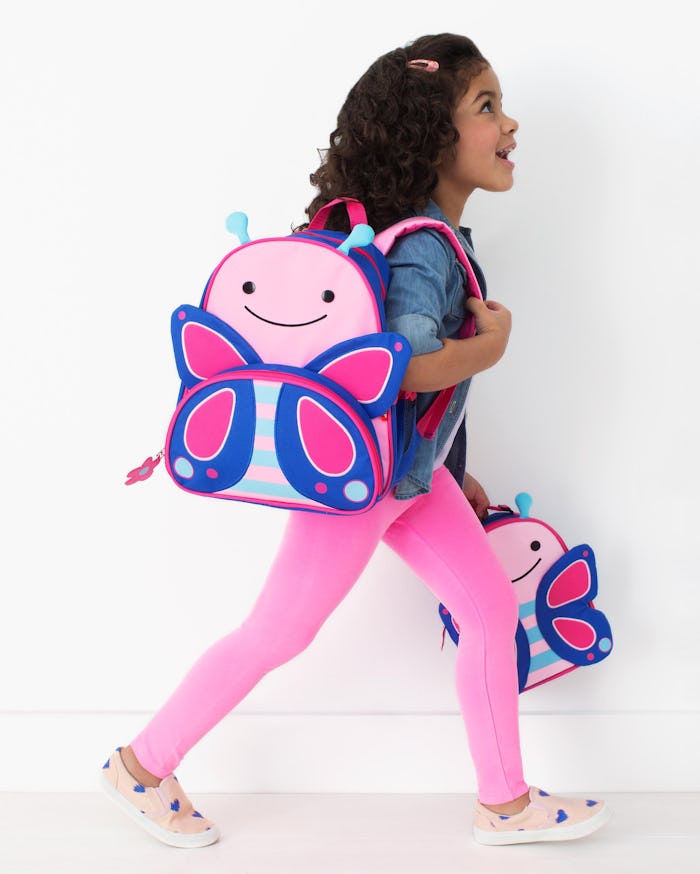 little girl wearing a butterfly backpack