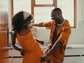 Young woman and Virgo man in love, dancing in their kitchen.