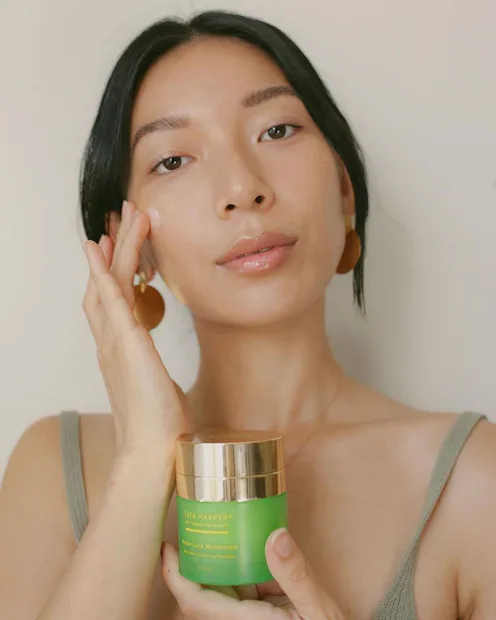 tata harper model applying moisturizer