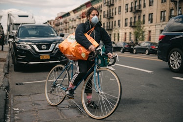 A woman with two big bags on a bike