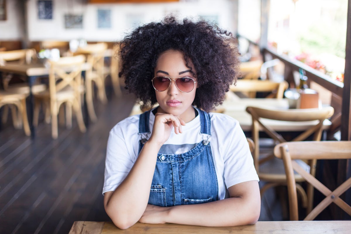 Young woman sitting and thinking in sunny cafe, showing her most secret fear, according to her zodiac sign.