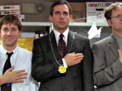 Jim Halpert, Michael Scott, and Dwight Schrute stand on podiums for 'The Office' Olympics episode.