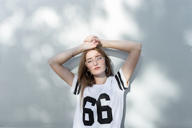 Young woman, wearing T-shirt with number 66, showing her most secret fear, according to her zodiac s...