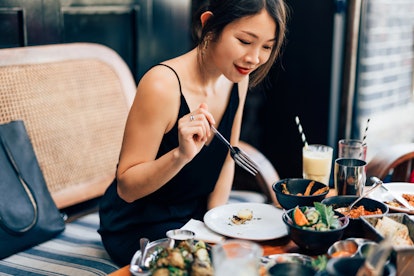 Young woman eating at a fancy restaurant on her birthday alone.