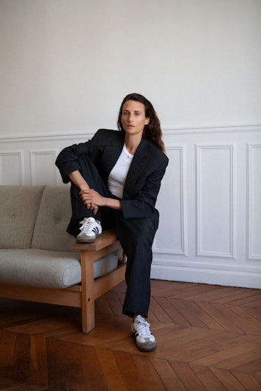 camille cottin sits at the end of a couch