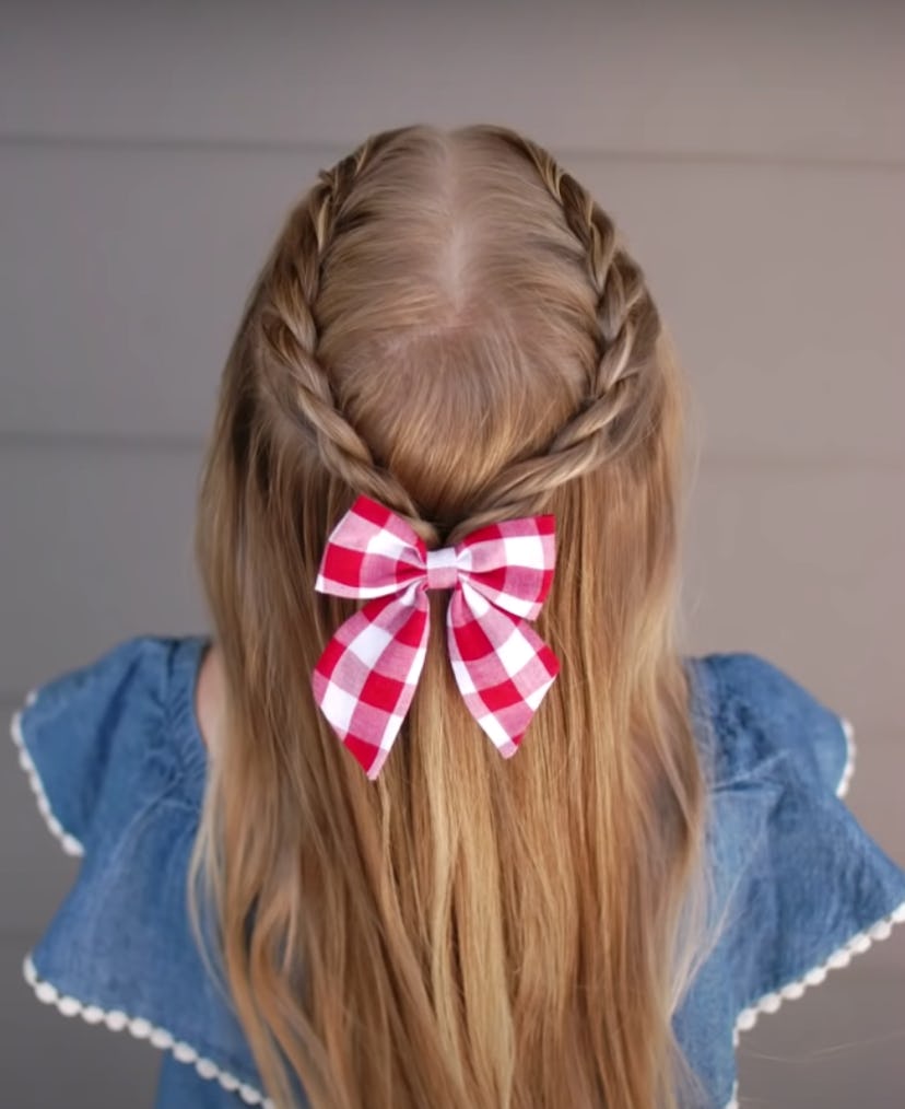Back of little girl's head, half up style hair with rope braid and red and white gingham bow