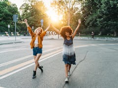 2 friends walking together holding hands in the city at sunset before posting funny birthday caption...