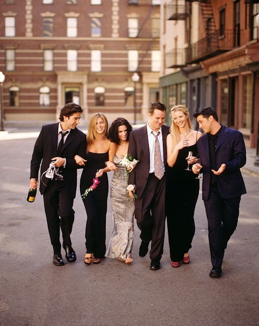 Cast of "Friends" TV show linking arms, walking down a street