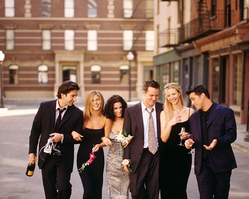 Cast of "Friends" TV show linking arms, walking down a street