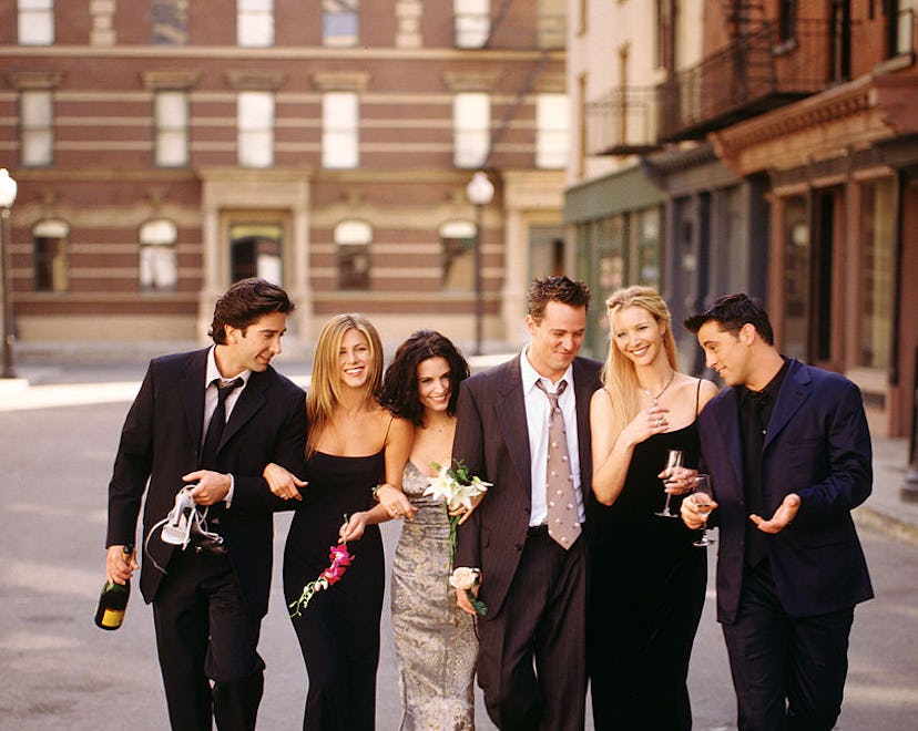 Cast of "Friends" TV show linking arms, walking down a street