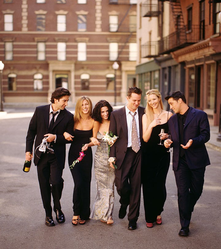 Cast of "Friends" TV show linking arms, walking down a street