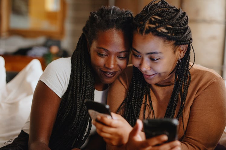 2 sisters looking at their phone, wondering what comment to post on sister pic.