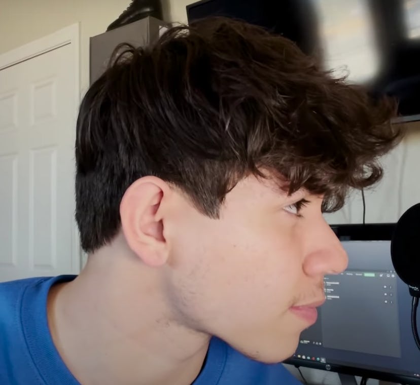 Teen with his head turned to the side, showing off messy long hair style