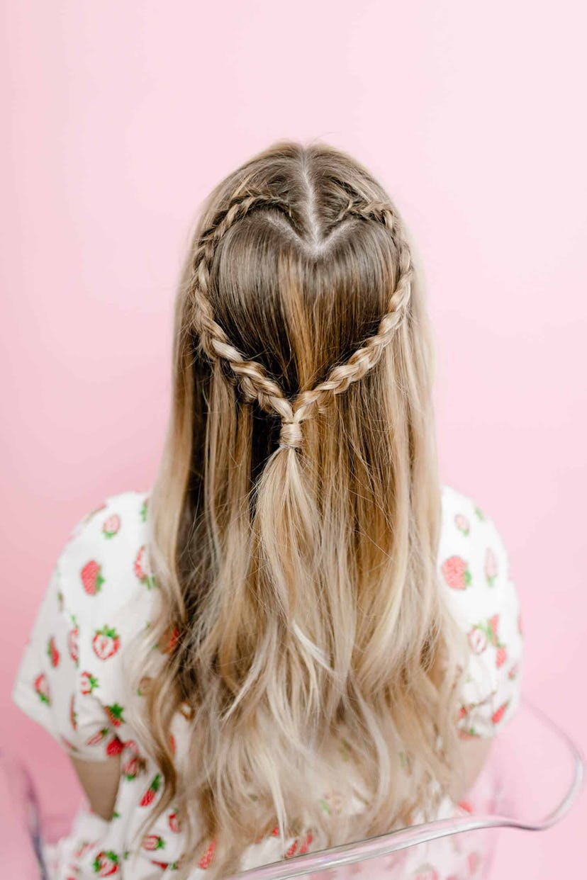 Back view of a person with long hair with half-up braid styled in the shape of a heart